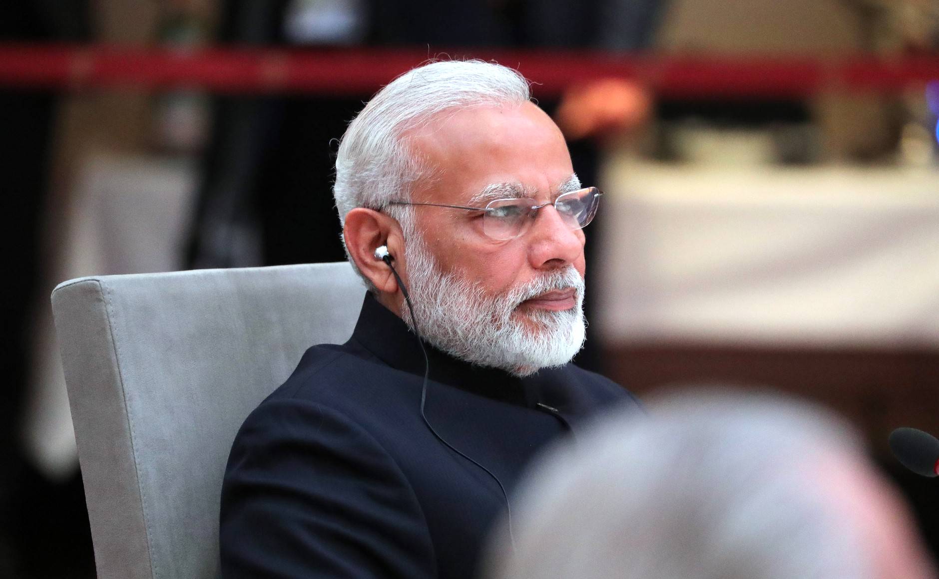 The Prime Minister of India, Modi, is shown sitting.
