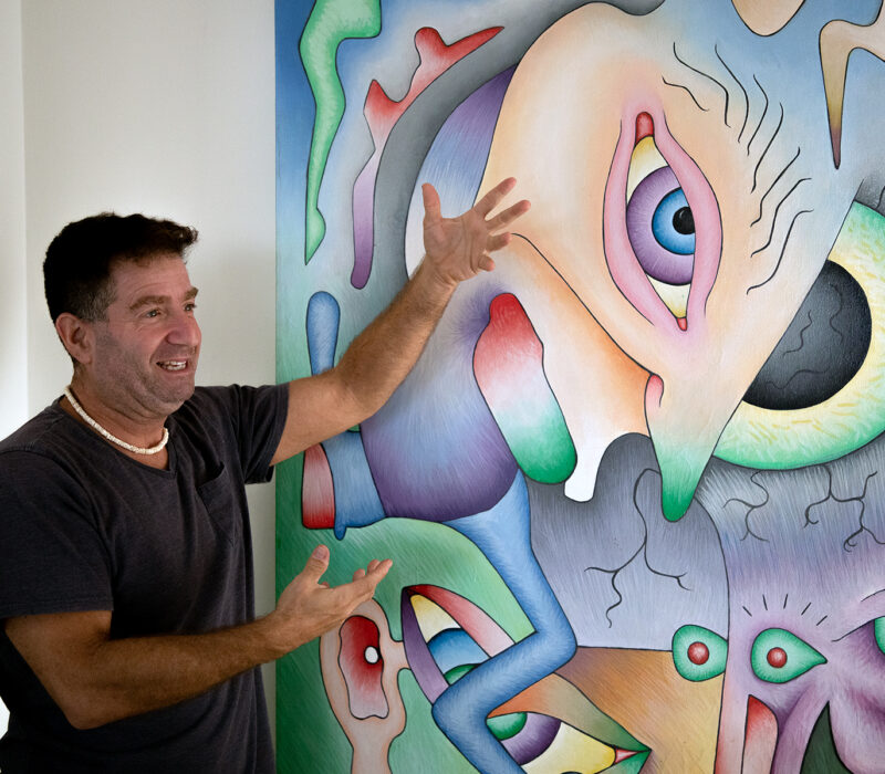 Golub explains his art on the wall. It is one of his earlier works. Credit: Elena Luwa Yin.