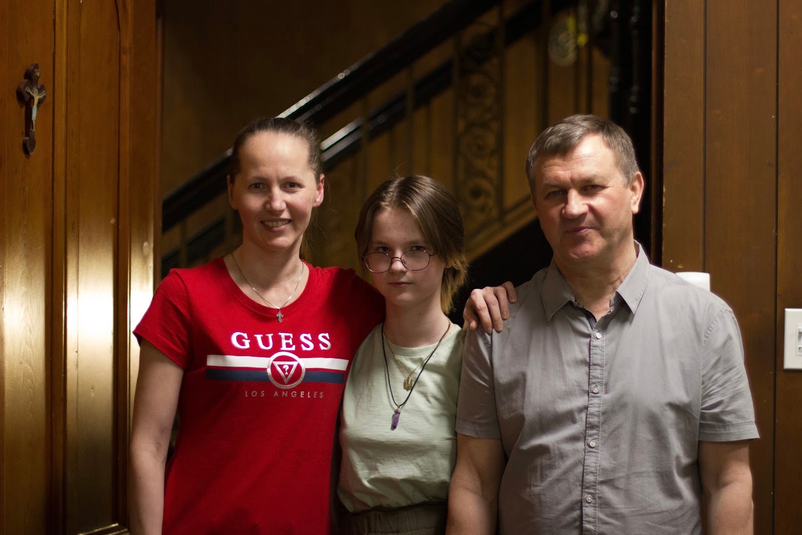 Tetiana Buria, Daria Nosova and Oleksandr Nosov next to the staircase leading up to their home (Credit: Ania Gruszczyńska)