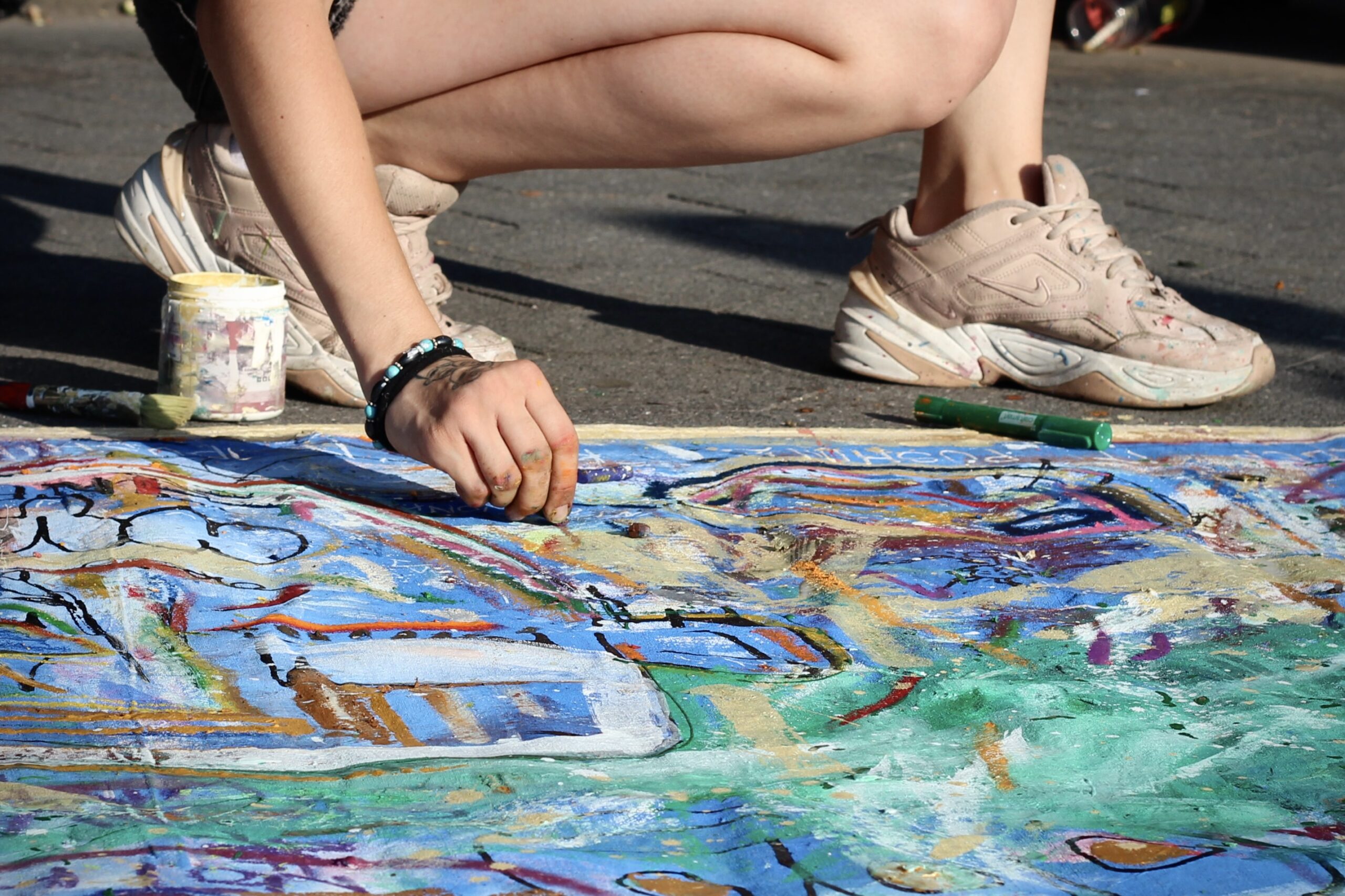 Elizabeth Yurovskaya, 22, who goes by the name ZilFutura, paints in Washington Square Park. Yurovskaya says she has been asked by police to pack up her art before, a request she complied with. “I didn’t want trouble.” (Credit: Mukta Joshi)