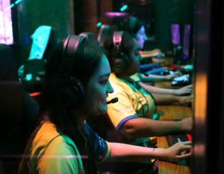 Female gamers are shown in front on their gaming setups. (Credit: Pace University)