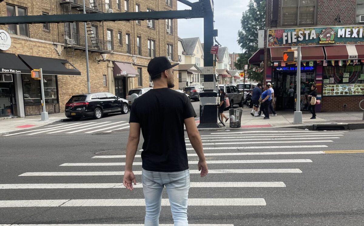 Henderson Sosa walking across Roosevelt Avenue, in Queens, trying to find a business in the neighborhood that could offer him a job. (Credit: Gabriela Henriquez)