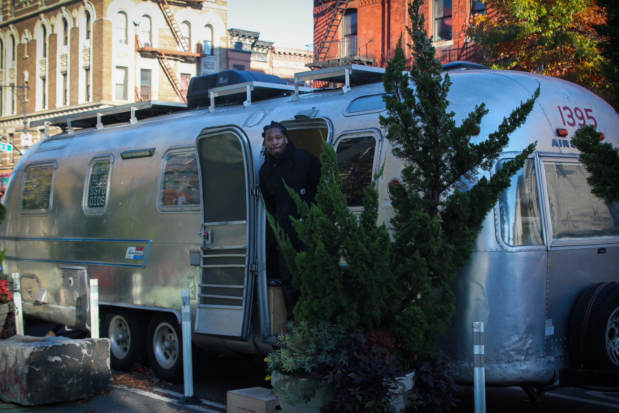 Kevin Claiborne peers out of Free Film: NYC’s trailer in Harlem’s Johnny Hartman Plaza. (Credit: Jolie Tanner)