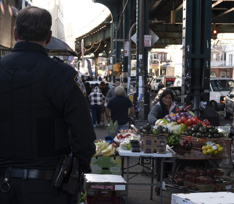 An NYPD officer tells an unlicensed street vendor to move from the street. (Credit: Mariana Hernandez)