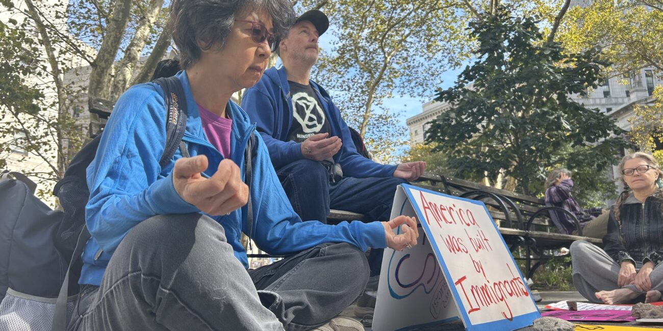 Siuli Gogwilt (left) and Richard Green (middle) meditating with Verne Zimmer (right) at Foley Square. (Credit: Hannah Smith)