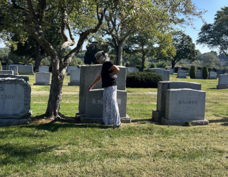 Amy Schimmel, 69, at Sharon Gardens Cemetery in Westchester, NY, where she places a stone on the headstone of her aunt and uncle. Sept. 15, 2025. (Credit: Mia Anzalone)