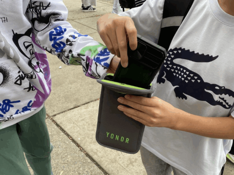 A student removes his smartphone from a Yondr pouch. (Credit: Karthik Vinod)