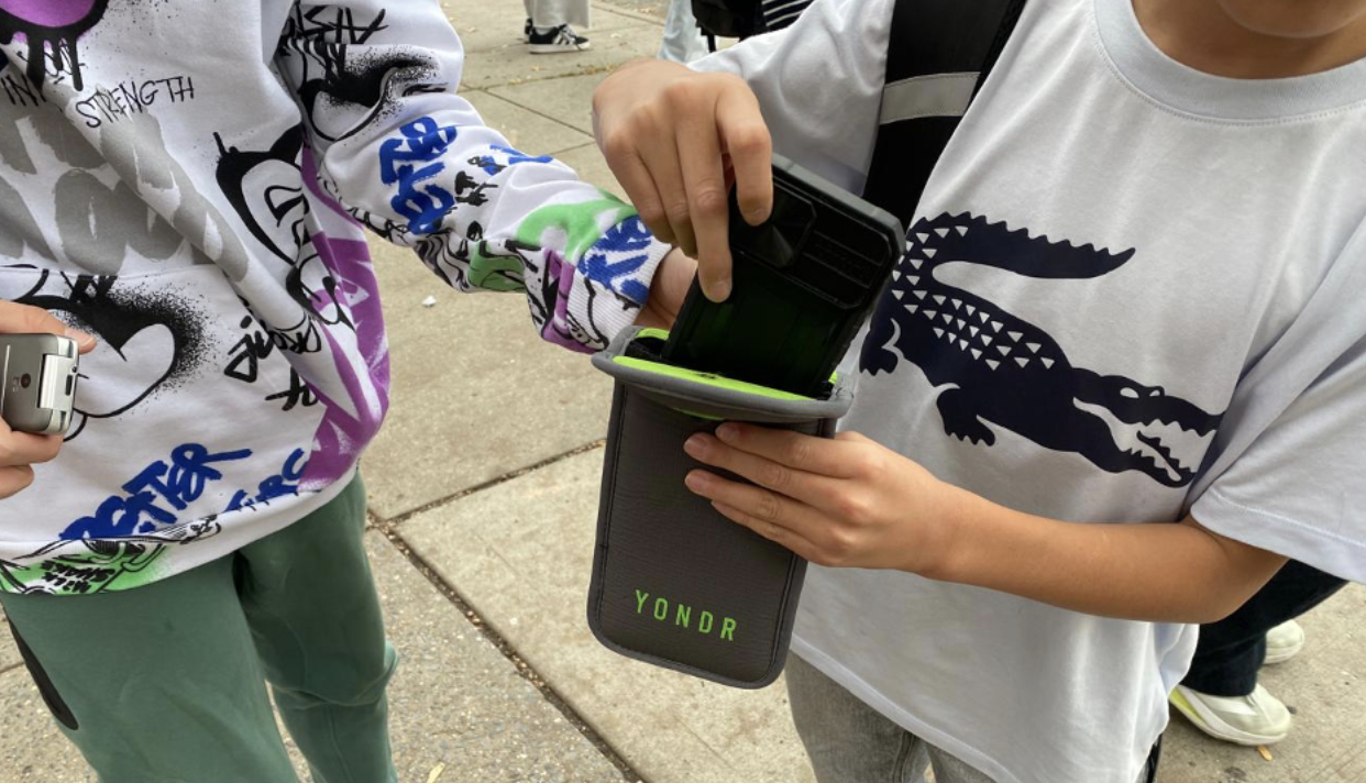 A student removes his smartphone from a Yondr pouch. (Credit: Karthik Vinod)