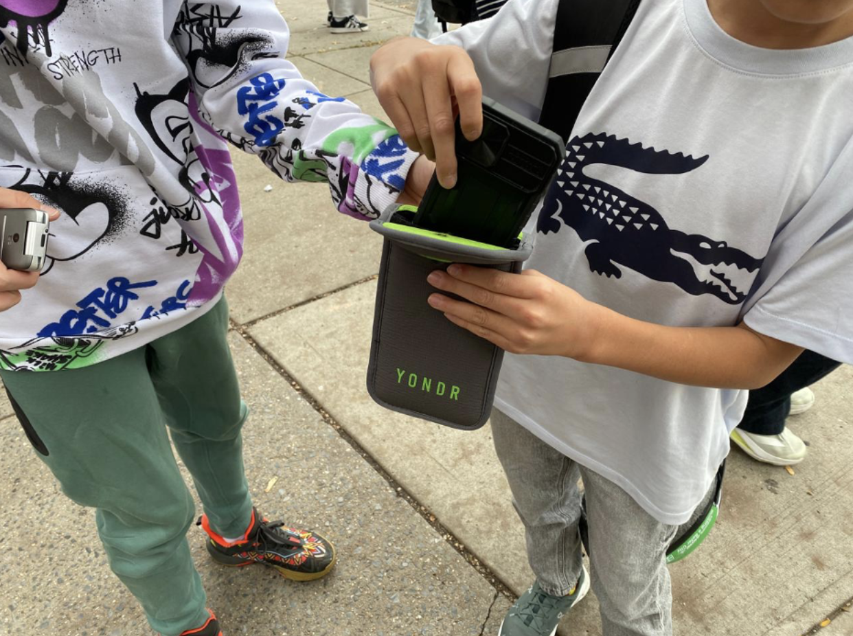 A student removes his smartphone from a Yondr pouch. (Credit: Karthik Vinod)