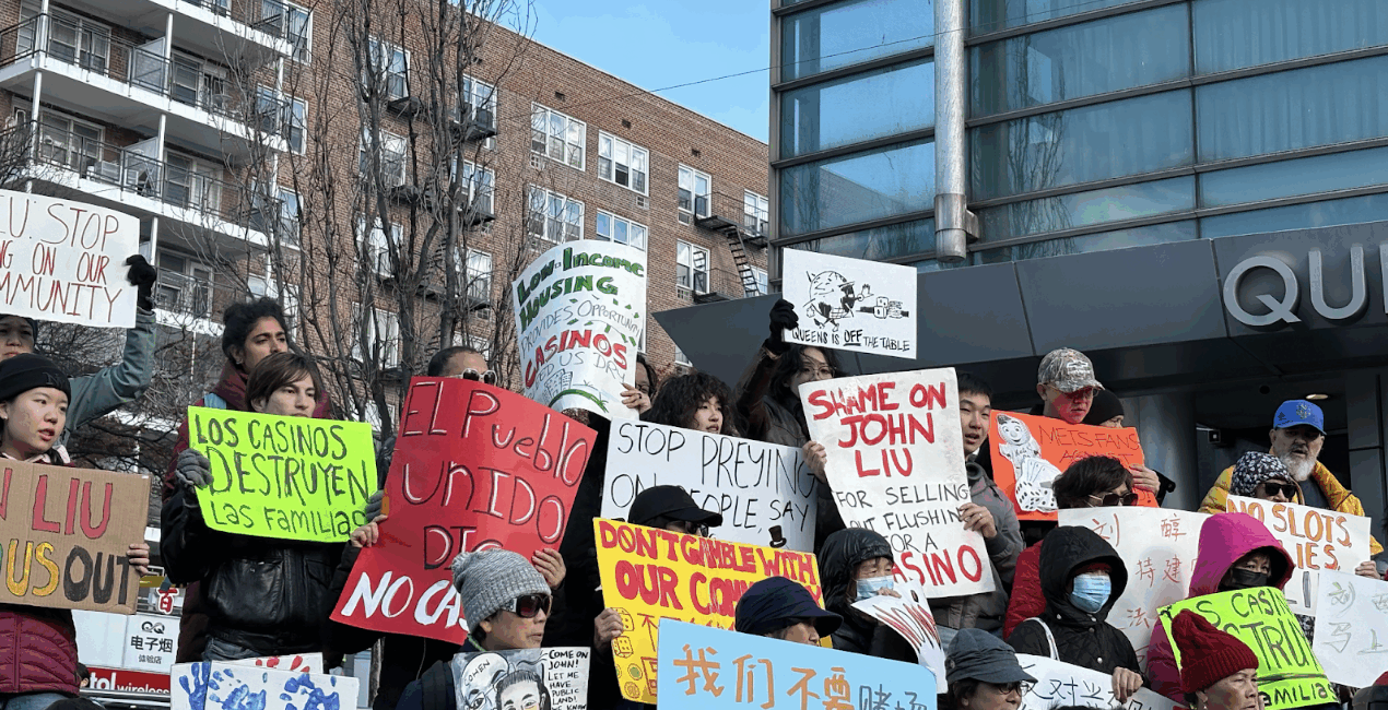 Demonstrators held signs on the Queens Library Steps on Nov. 16. (Credit: Olivia Morrison)