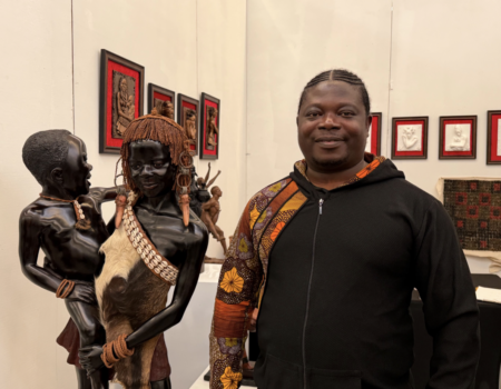 Samuel Kumi stands beside one of his sculptures at the Harlem Fine Arts Show on Feb. 20. (Credit: Anna Lee)