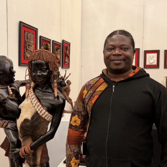 Samuel Kumi stands beside one of his sculptures at the Harlem Fine Arts Show on Feb. 20. (Credit: Anna Lee)