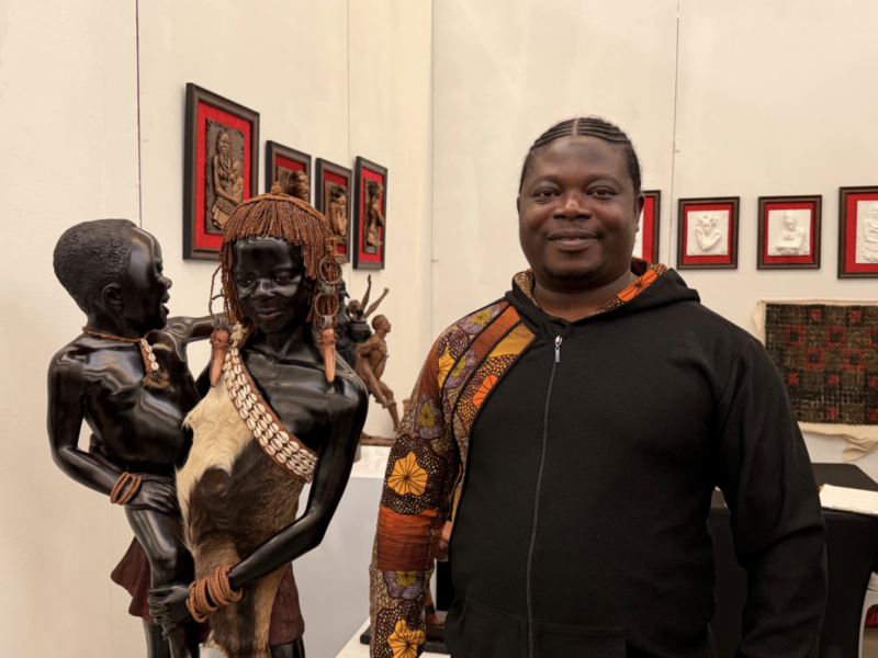 Samuel Kumi stands beside one of his sculptures at the Harlem Fine Arts Show on Feb. 20. (Credit: Anna Lee)