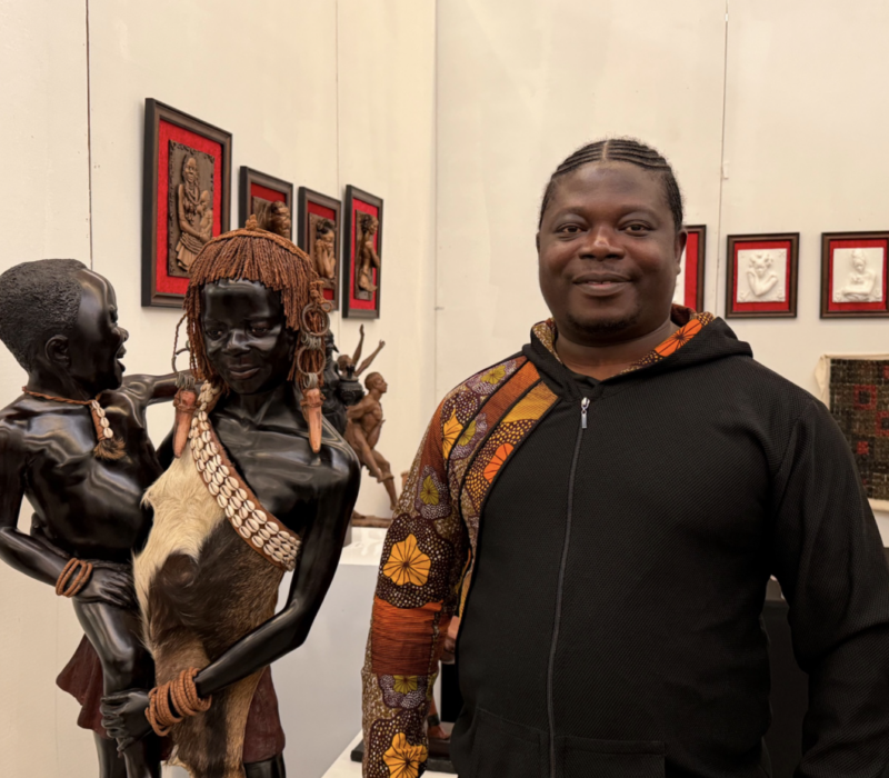 Samuel Kumi stands beside one of his sculptures at the Harlem Fine Arts Show on Feb. 20. (Credit: Anna Lee)