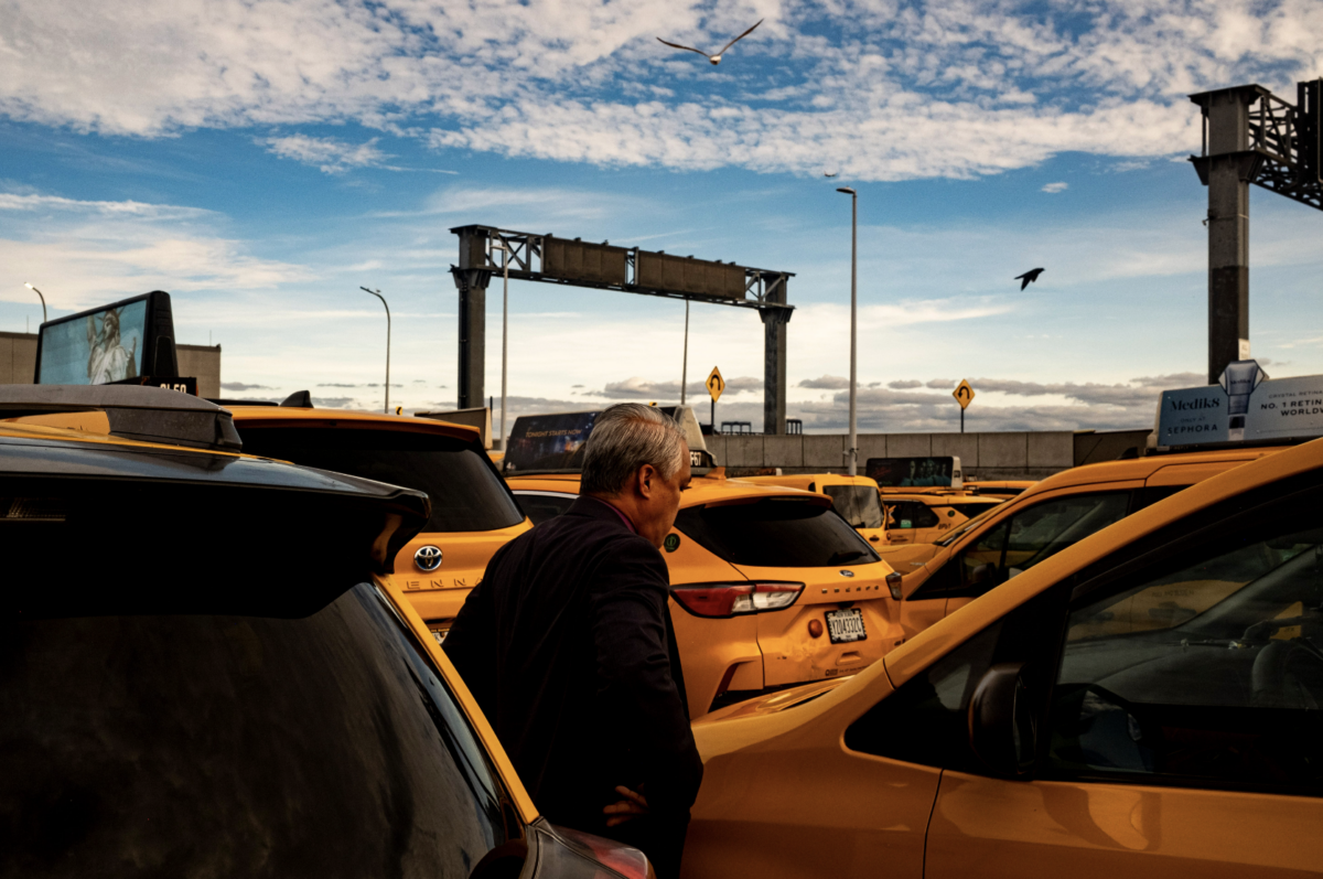 Norman Buenvaentura stands beside his taxi. (Credit: Liam Kennedy)