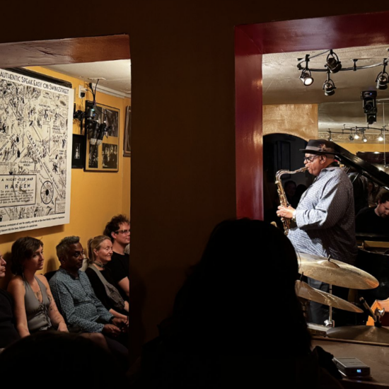 Bill Saxton plays the saxophone facing 1932 cartoon of Harlem streets replete with clubs. His is now the last authentic jazz club in the area.(Credit: Ana Federica Wallis)